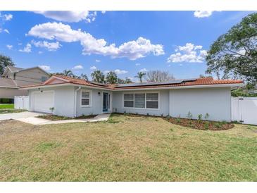 Charming single-story home with a red tile roof, solar panels, and a well-manicured lawn at 4395 50Th S Ter, St Petersburg, FL 33711
