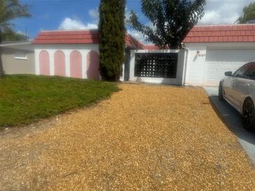Charming single story home with a gravel driveway and barrel tile roof at 5137 Manor Dr, New Port Richey, FL 34652