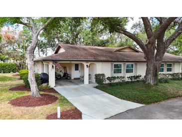 Charming single story home with an arched covered entrance, golf cart, and a well-manicured lawn at 2011 Halidom Way # 0, Sun City Center, FL 33573