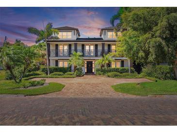 Charming two-story home with a brick driveway, lush landscaping, and symmetrical design at 2320 Coffee Pot Ne Blvd, St Petersburg, FL 33704