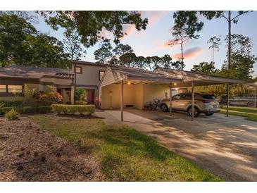 Charming townhouse with a covered carport and well-maintained landscaping, perfect for convenient parking and curb appeal at 25 Woods Landing Trl, Oldsmar, FL 34677