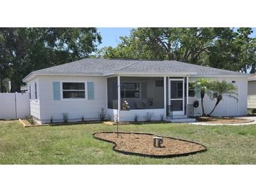 Charming white home features a lovely screened-in porch and fresh landscaping at 4550 53Rd N Ave, St Petersburg, FL 33714