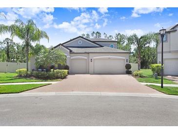 Charming two-story home featuring a spacious three-car garage and well-manicured landscaping at 10703 Morning Dew Way, Tampa, FL 33647