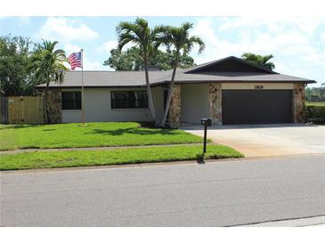 Charming single-story home with stone accents, lush lawn, and mature palm trees at 12619 98Th St, Largo, FL 33773