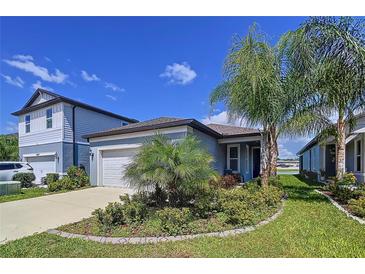 Charming single-Gathering home with a well-manicured lawn, mature trees, and attached one-car garage at 20983 Monza Loop, Land O Lakes, FL 34638