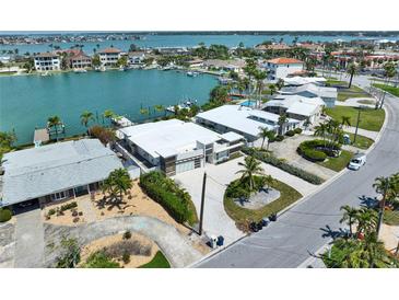 Stunning waterfront home featuring lush landscaping and a private dock on a canal leading to the open bay at 25 Dolphin Dr, Treasure Island, FL 33706
