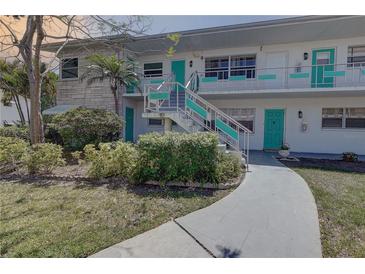 Charming condo with well-maintained landscaping, teal doors and stairs at 5810 21St N St # 10, St Petersburg, FL 33714