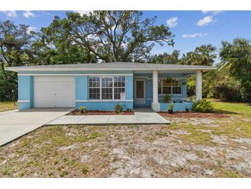 Charming, light-blue single story home with attached garage and a cozy, welcoming front yard at 711 6Th Ne St, Largo, FL 33770