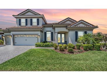 Charming two-story home with a well-manicured lawn, a two-car garage, and a tile roof at 13121 Pasture View Loop, Riverview, FL 33579