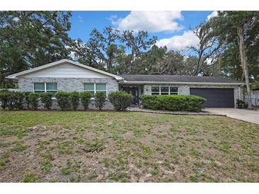 Charming single-story home featuring a brick facade, well-maintained landscaping, and a two-car garage at 215 Deer Park Ave, Temple Terrace, FL 33617