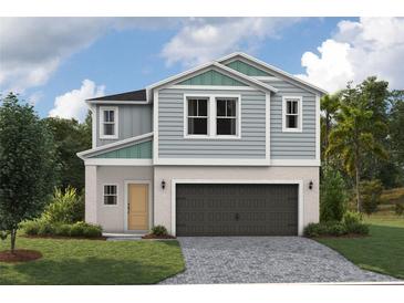 Charming two-story home with blue siding, a stone-paved driveway, and a two-car garage at 37252 Sagemoor Dr, Zephyrhills, FL 33541