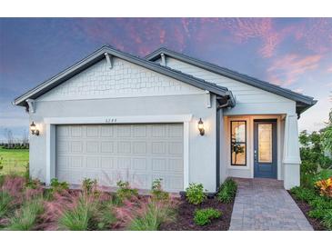Charming single-Gathering home featuring a grey garage door and beautiful landscaping at 4650 Blue Star Ct, North Port, FL 34289