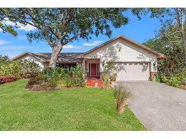 Charming single-story home with lush landscaping and a vibrant red front door, creating an inviting curb appeal at 7201 15Th Ne Ct, St Petersburg, FL 33702