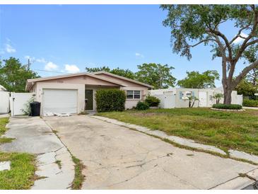 Charming single-story home featuring a well-maintained lawn and an attached one-car garage at 1759 Massachusetts Ne Ave, St Petersburg, FL 33703