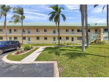 Inviting two-story condo building with a well-maintained lawn and beautiful landscaping at 2005 Greenbriar Blvd # 7, Clearwater, FL 33763