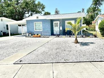 Charming single-story home with blue siding, a well-manicured yard, and a young palm tree at 3318 Boca Ciega N Dr, St Petersburg, FL 33710
