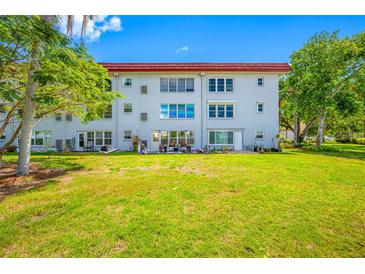 Building exterior view with a grassy yard and patio seating for outdoor enjoyment at 5660 80Th N St # D207, St Petersburg, FL 33709