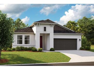 Contemporary home featuring stucco exterior, two-car garage, well-manicured lawn, and stylish architectural details at 12166 Cattleside Dr, Riverview, FL 33579