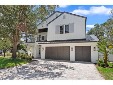 Stunning modern farmhouse with a three-car garage and inviting balcony at 3406 W Alline Ave, Tampa, FL 33611