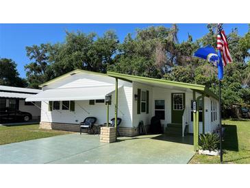 Charming single-story home featuring a well-maintained lawn, covered parking, and a welcoming front porch at 3829 Chah Dr, Zephyrhills, FL 33541