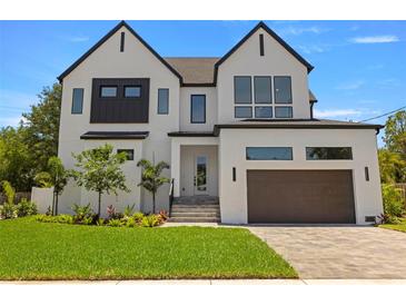 Stunning two-story home boasts modern design, white brick, black accents, and a manicured front yard at 3020 W Helen Ave, Tampa, FL 33611