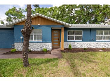Charming single-story home with blue paint, white stone accents, and a modern front door at 5806 12Th S Ave, Tampa, FL 33619