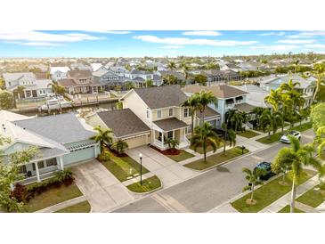Stunning aerial view of a home in a waterfront community with palm trees and well manicured lawns at 422 Islebay Dr, Apollo Beach, FL 33572