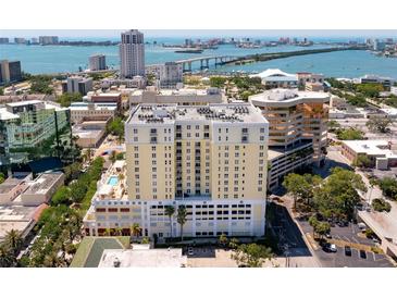 An aerial view showcases the condominium, along with waterfront scenery, bridges, and downtown buildings at 628 Cleveland St # 612, Clearwater, FL 33755