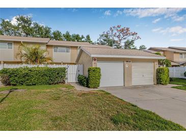 Charming townhome with attached garage, well-maintained lawn, and lush landscaping at 6497 Cape Hatteras Ne Way # 3, St Petersburg, FL 33702