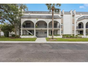 Charming condo building with an elegant arched entryway and lush landscaping at 122 N Kings Ave # 101, Brandon, FL 33510