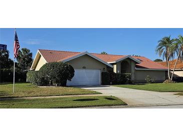 Charming single-story home with a red tile roof, well-maintained landscaping, and an attached two-car garage at 2704 E Montague E Ct, Clearwater, FL 33761