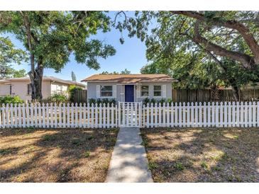 Charming home featuring a white picket fence, lovely yard, and inviting blue front door at 3510 4Th N Ave, St Petersburg, FL 33713