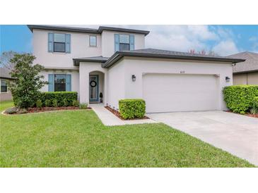 Charming two-story home featuring a well-manicured lawn and a two-car garage at 8219 Summer Brook Ct, Land O Lakes, FL 34638