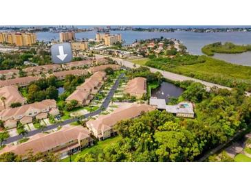 An aerial view of a residential community with mature landscaping and views of a body of water at 11246 Kapok Grand Cir, Madeira Beach, FL 33708