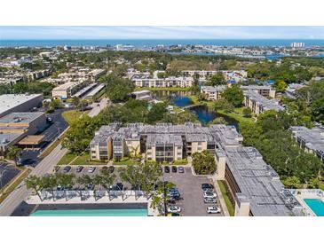 Condominium complex with mature trees and a lake with bridge offering serene water views at 14130 Rosemary Ln # 1202, Largo, FL 33774