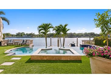 Beautiful backyard pool and spa with waterfront views, surrounded by lush landscaping at 927 Anchorage Rd, Tampa, FL 33602