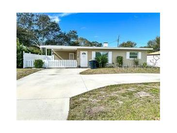 Charming single-story home featuring a well-maintained front yard and a classic white picket fence at 1228 Pineview Ave, Clearwater, FL 33756