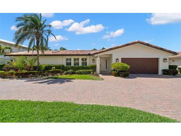 Charming one-story home featuring a red tile roof, manicured landscaping, and a brick driveway at 2057 Kansas Ne Ave, St Petersburg, FL 33703