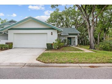 Charming single Gathering home with a well-manicured lawn and attached garage at 235 Woodridge Cir, Oldsmar, FL 34677