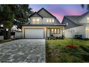 Charming two-story home with a well-manicured lawn and paver driveway at 3106 W Cherokee Ave, Tampa, FL 33611
