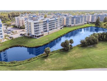 Aerial view of a condo community surrounding a pond with a fountain and well-manicured landscaping at 960 Starkey Rd # 7202, Largo, FL 33771