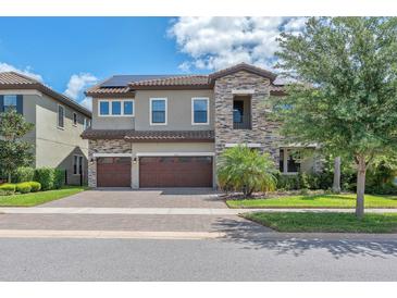 Charming two-story home with stone accents, three-car garage, and well-manicured landscaping at 11227 Hawks Fern Dr, Riverview, FL 33569