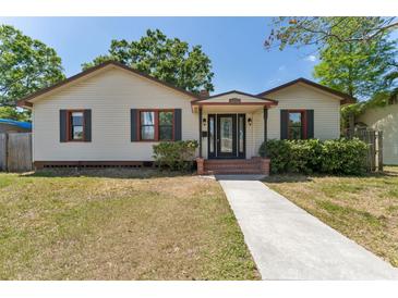 Charming single Gathering home with tan siding, black shutters, and a walkway leading to the front door at 4410 19Th N St, St Petersburg, FL 33714