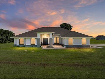Beautiful single-story home with large front yard, brick accents, and a welcoming entrance against a colorful sunset sky at 1292 Myers Rd, Brooksville, FL 34602