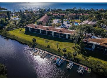 An aerial shot reveals a waterfront condo complex with docks and a pool, offering scenic views at 1686 Seascape Cir, Tarpon Springs, FL 34689