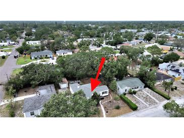 Charming home with a gray roof is nestled among lush trees and landscaping in a residential neighborhood at 235 38Th S St, St Petersburg, FL 33711