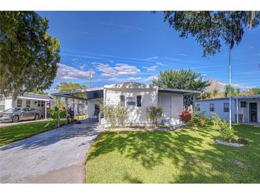 Charming single-story home boasts a well-maintained lawn and convenient covered parking at 6044 Alpine Dr, Zephyrhills, FL 33542