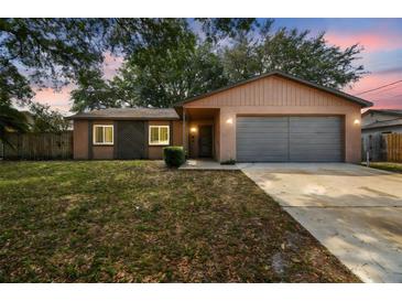 Charming single-story home featuring a gray garage door and a well-maintained lawn at 16039 Frost Dr, Hudson, FL 34667