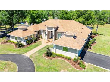 Stunning single-story home with a beautifully landscaped yard, circular driveway, and grand entrance at 30723 Reed Rd, Dade City, FL 33523