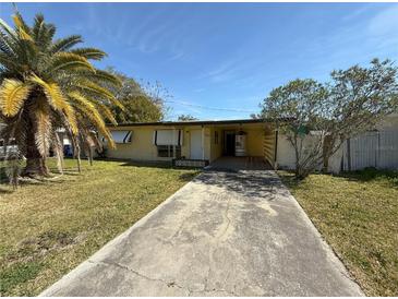 Charming single-story home featuring a well-kept lawn and a sunny, open front yard with a large palm tree at 7365 Royal Palm Dr, New Port Richey, FL 34652
